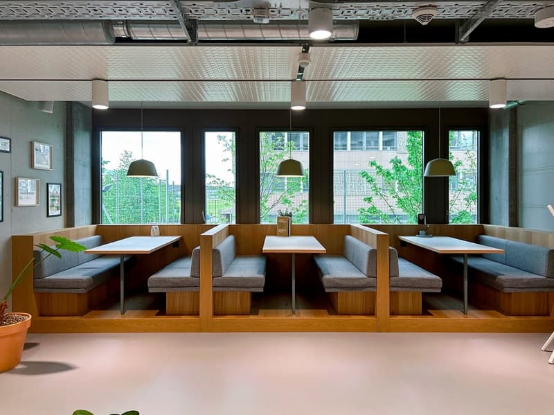 Wooden benches, wooden tables, potted plants, ceiling lamps, pictures on the wall, windows, outdoor view