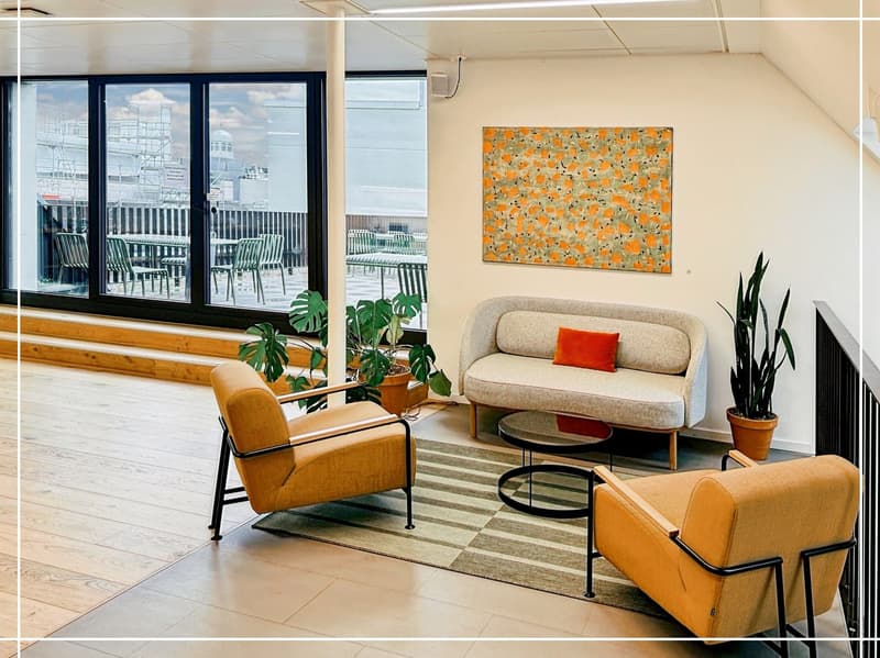 modern living room with beige sofa, two armchairs, coffee table, rug, plants, large windows, balcony with tables and chairs