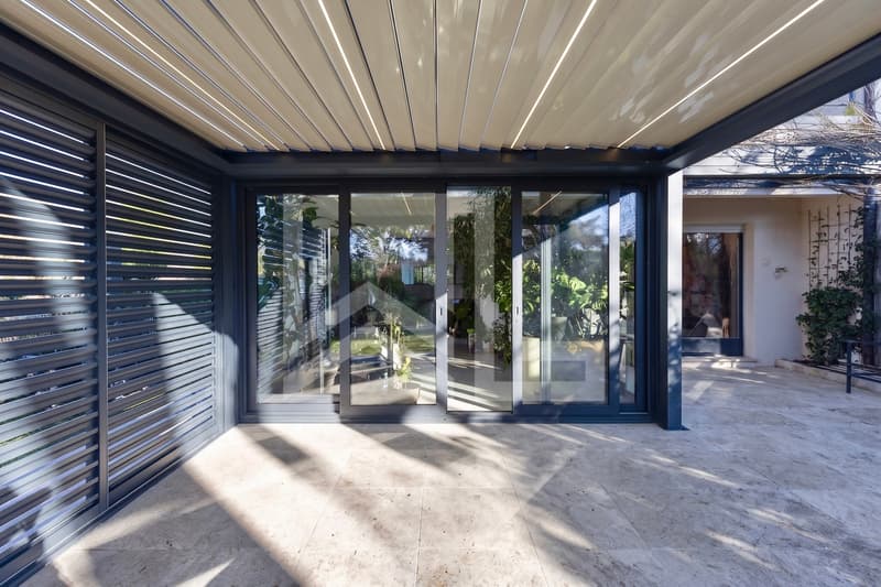 Corsier / the entrance to this modern home has large sliding glass doors that lead to a courtyard