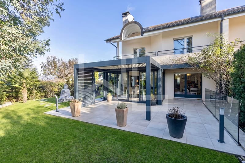 Corsier / a modern house with a large patio in the backyard