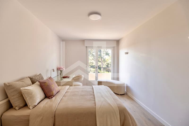 Corsier / a white room with a double bed, chair and large window