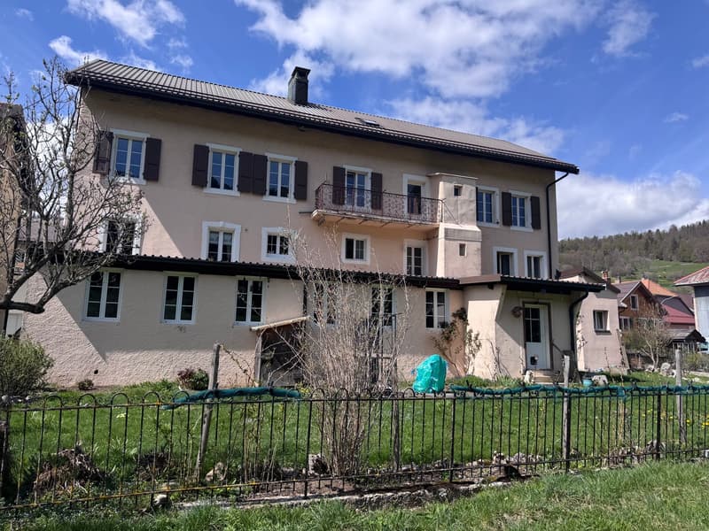 3 story house, beige exterior, multiple windows, balcony, chimney, fenced yard