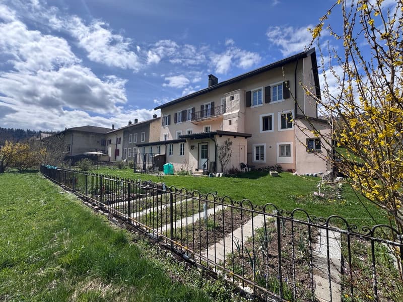 3 story house, beige exterior, multiple windows, balcony, garden, fence
