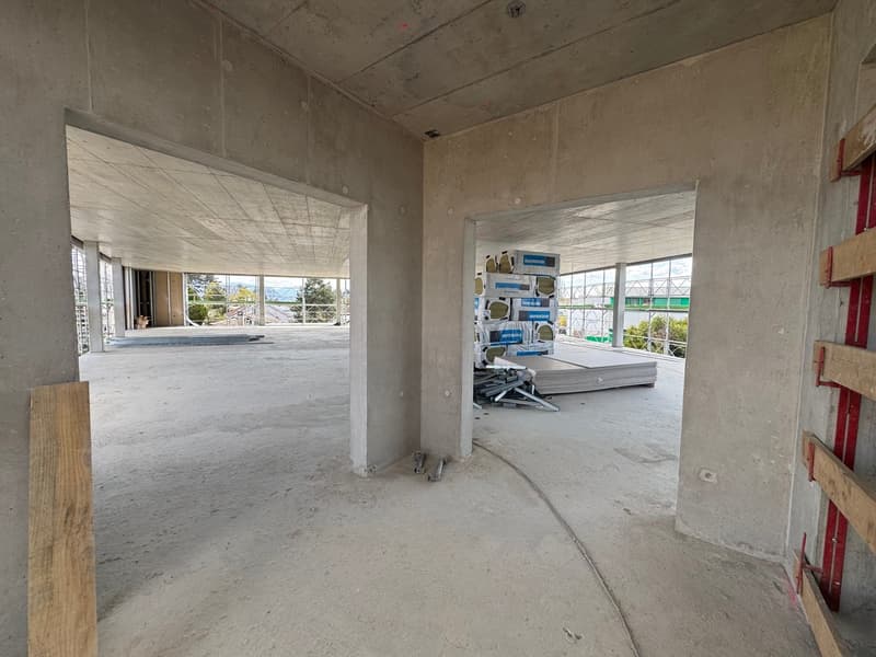 unfinished room, concrete walls, open space, large windows, construction materials