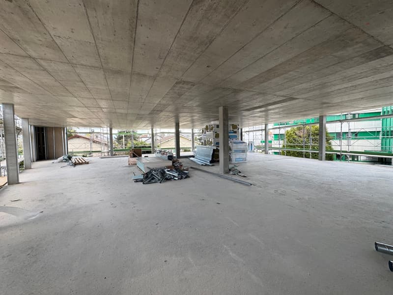 Under construction building, concrete floor, metal beams, construction materials scattered