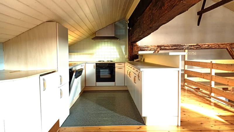 Rustic kitchen with wooden beams, white cabinets, stove, oven, refrigerator, and shelving units