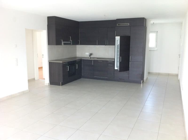 modern kitchen with white floor tiles, black cabinets, countertop, stainless steel sink, open layout