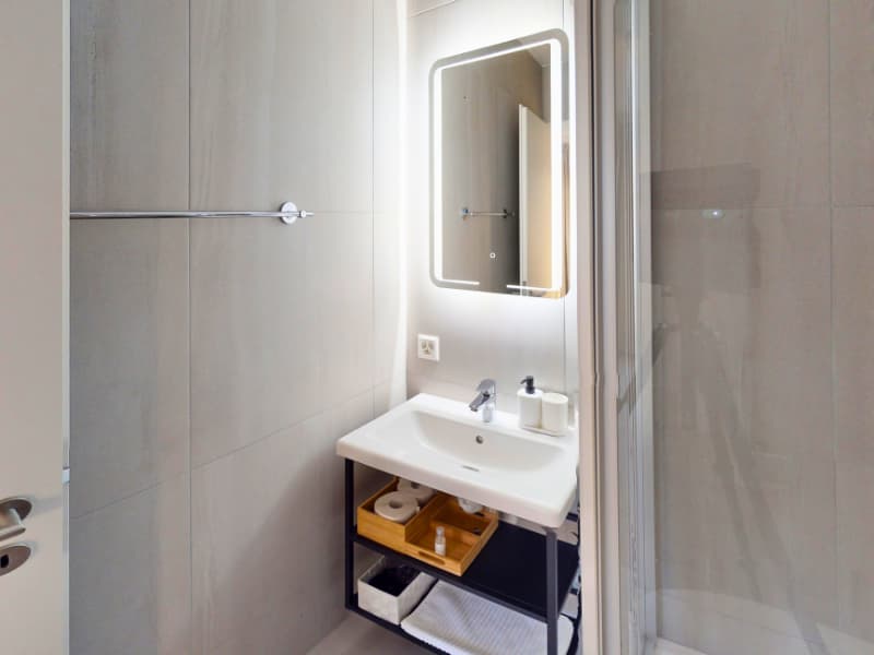 bathroom with sink, mirror, shower, toilet