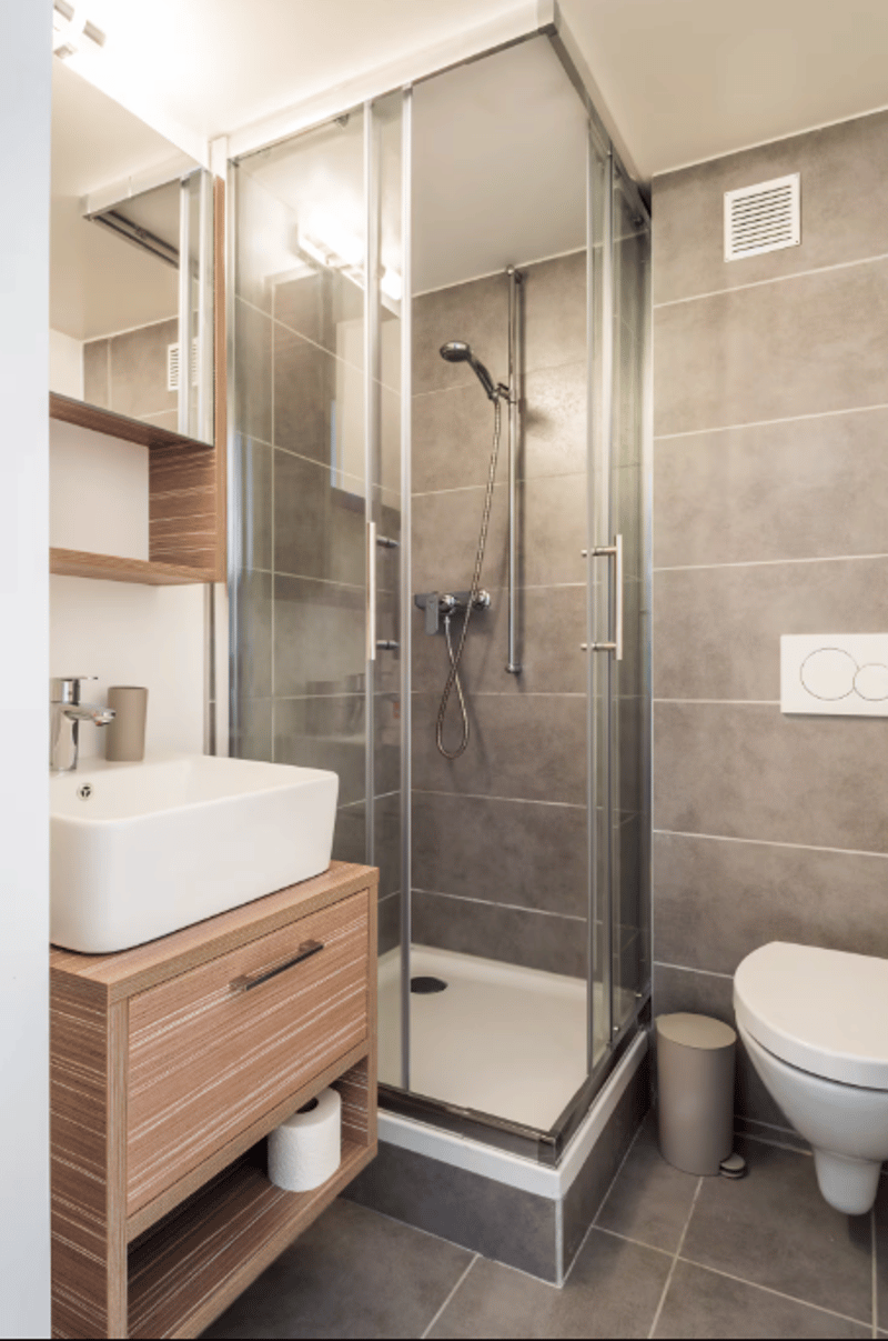 modern design with walk-in shower, sink, toilet, wooden cabinet