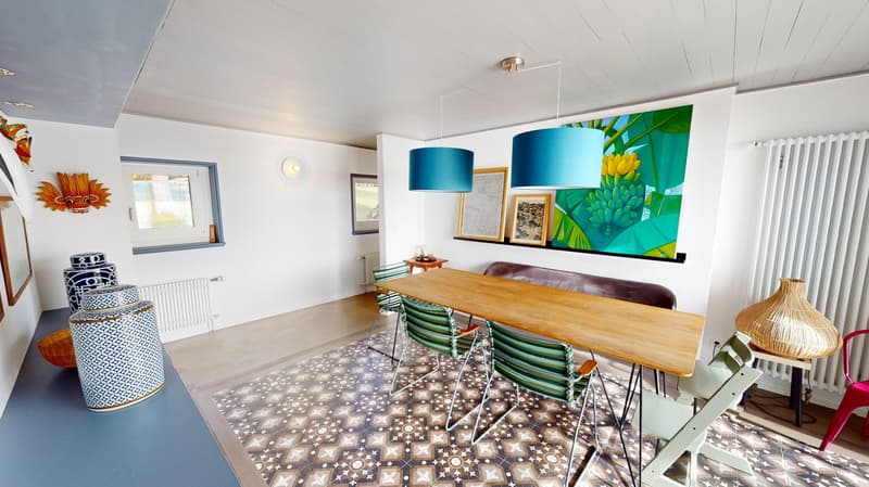 Dining room with wooden table and chairs, colorful design, two lamps, carpet, wall decor