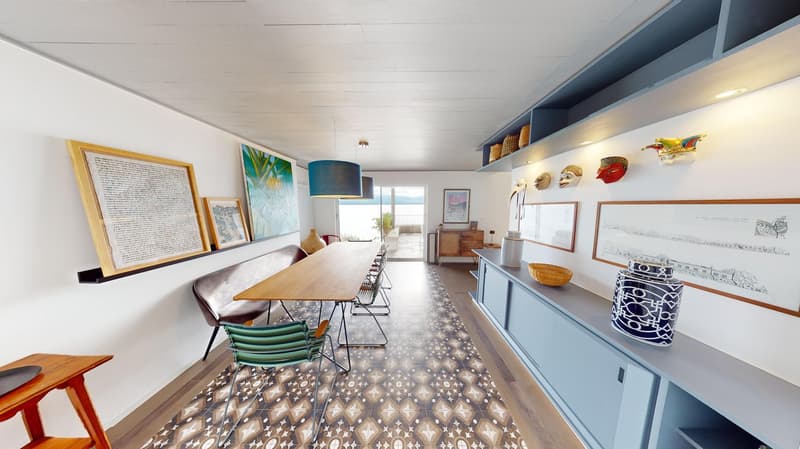 dining area with long table, chairs, cabinets, artwork on the wall, view of outside