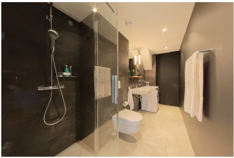 shower, sink, toilet, towels, tiles, dark wall
