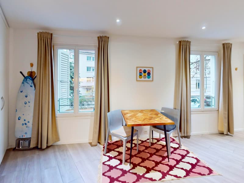 dining room with a wooden table, chairs, rug, windows, picture frame