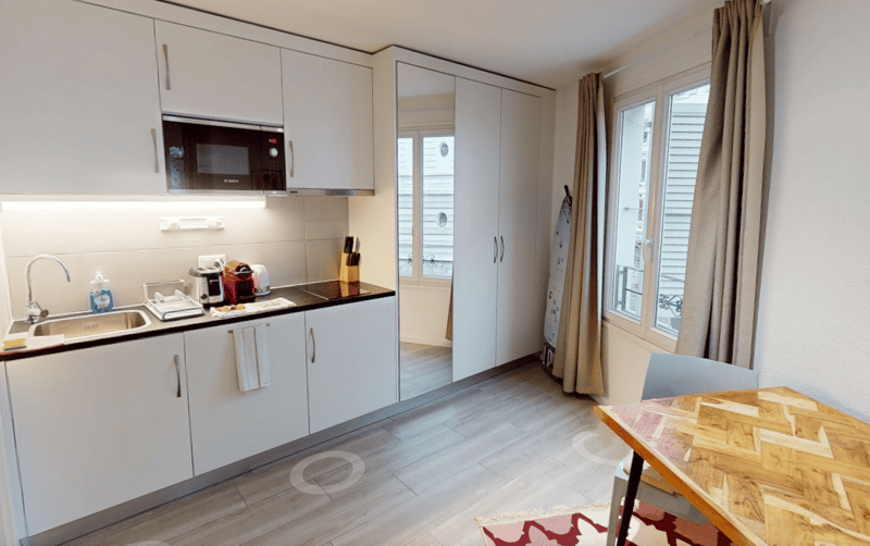 modern kitchen, white cabinets, wooden floor, sink, microwave, toaster, coffee maker, cutlery block, countertop, windows