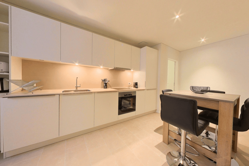 modern, clean, white cabinetry, stainless steel appliances, granite countertops, wooden table, bar stools, under cabinet lighting