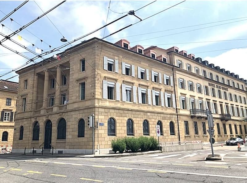 5-story building, tan brick, arched windows, central entrance, decorative balconies