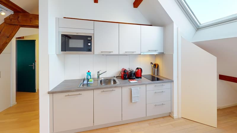 kitchen, microwave, fridge, washing machine, sink, gas stove, wooden floor, wooden beams
