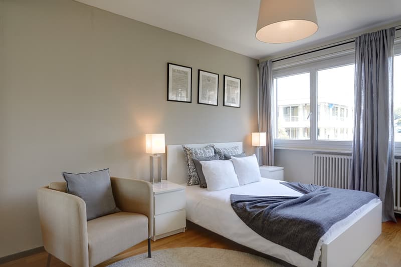 bedroom with bed, chair, nightstands, lamps, rug, pictures, curtains, radiator