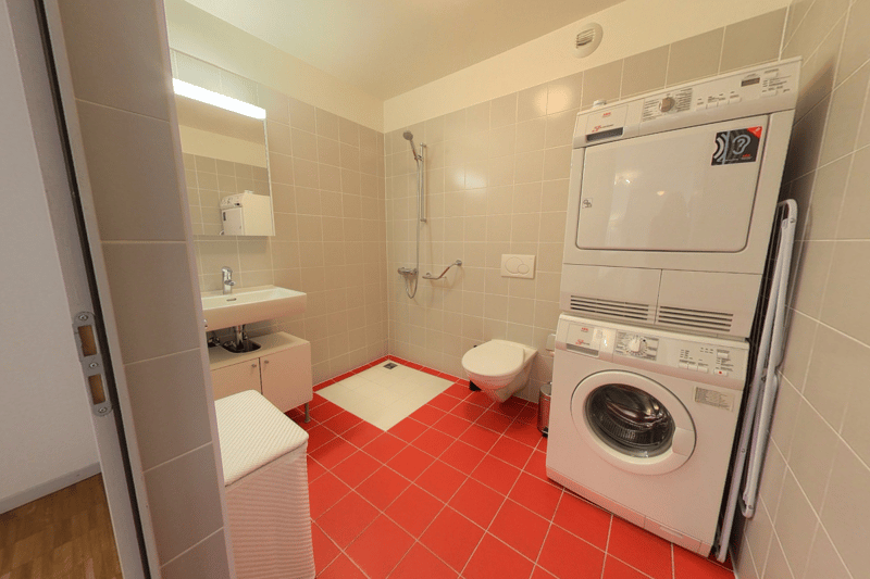 Bathroom with sink, toilet, washing machine, and dishwasher.
