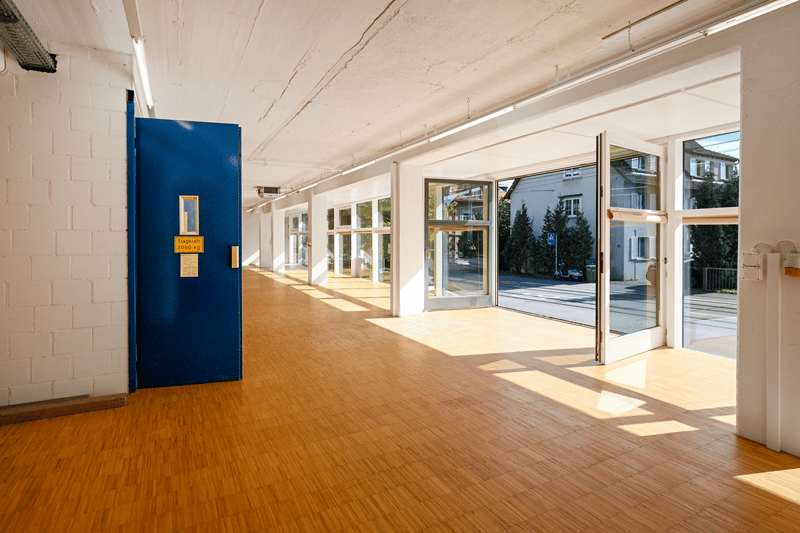empty hallway, wooden flooring, white walls, blue door, open doors leading to exterior