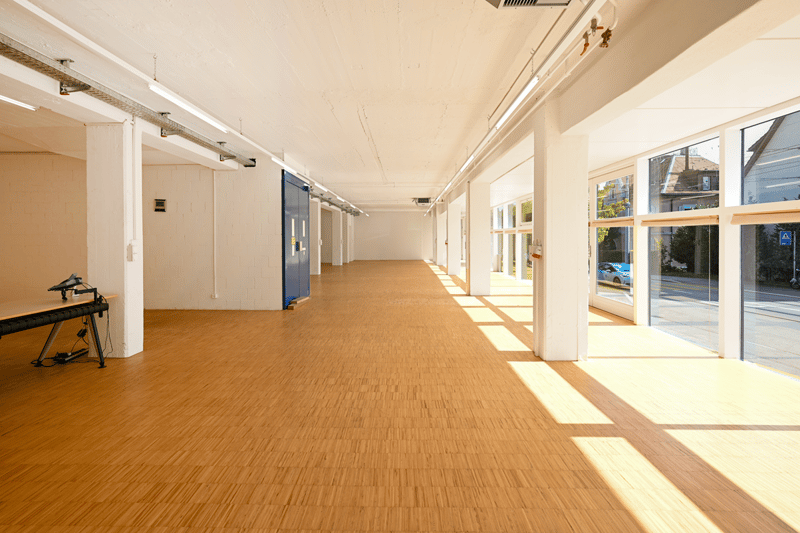 empty room, wooden flooring, bright lighting, long corridor, large windows