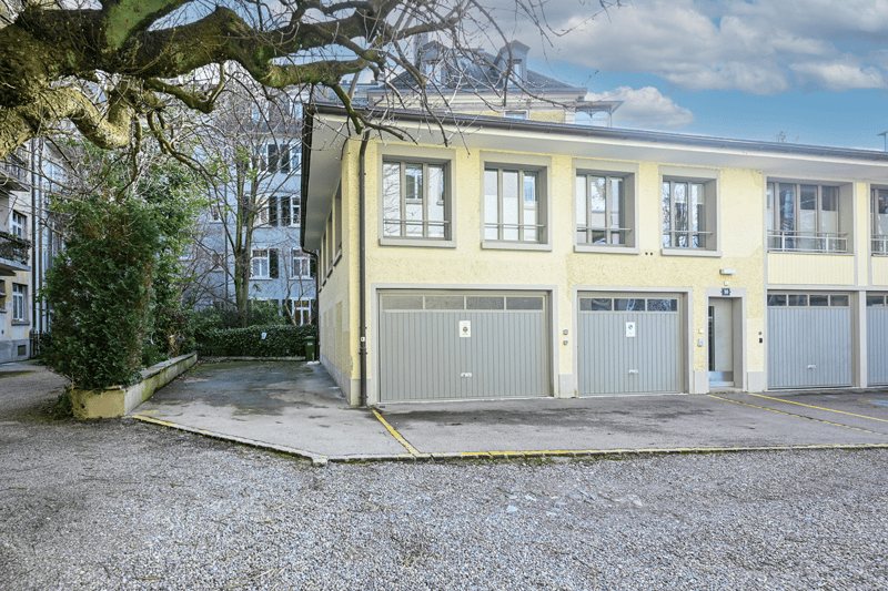 Two-story yellow building with garage and driveway