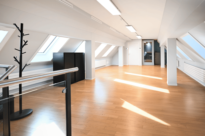 empty room, wooden floor, white walls, glass windows, metal railings, coat rack