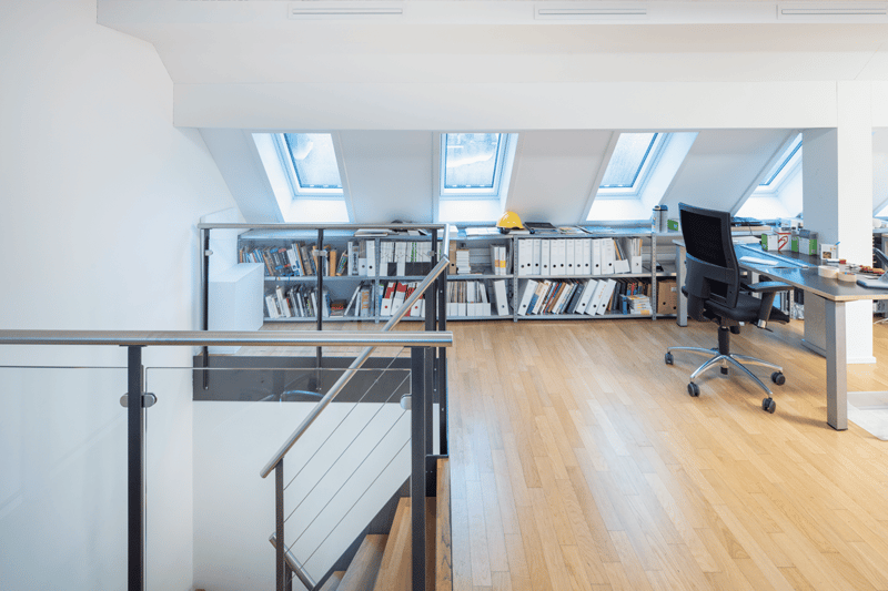 wooden floor, white walls, office desk, office chair, bookshelves, skylights