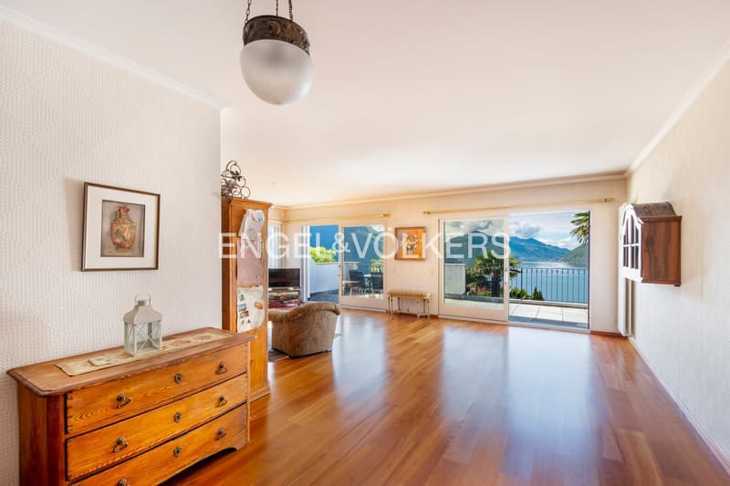 wooden floor, large windows with balcony overlooking the lake and mountains