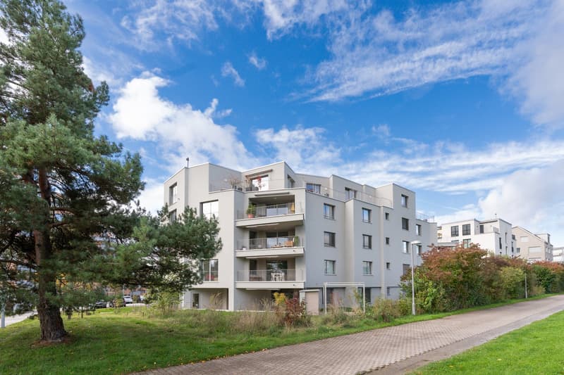 multi-story building, balconies, green spaces
