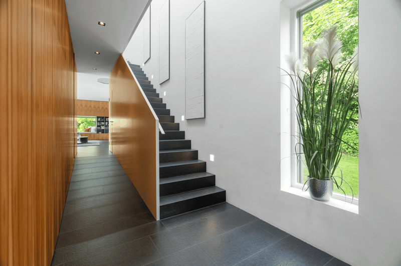 wooden wall, tiled floor, large window, plant on the window sill, staircase