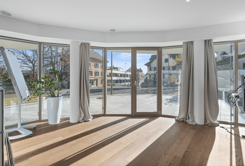 Large window with panoramic view, wooden floor, potted plant, curtains, whiteboard