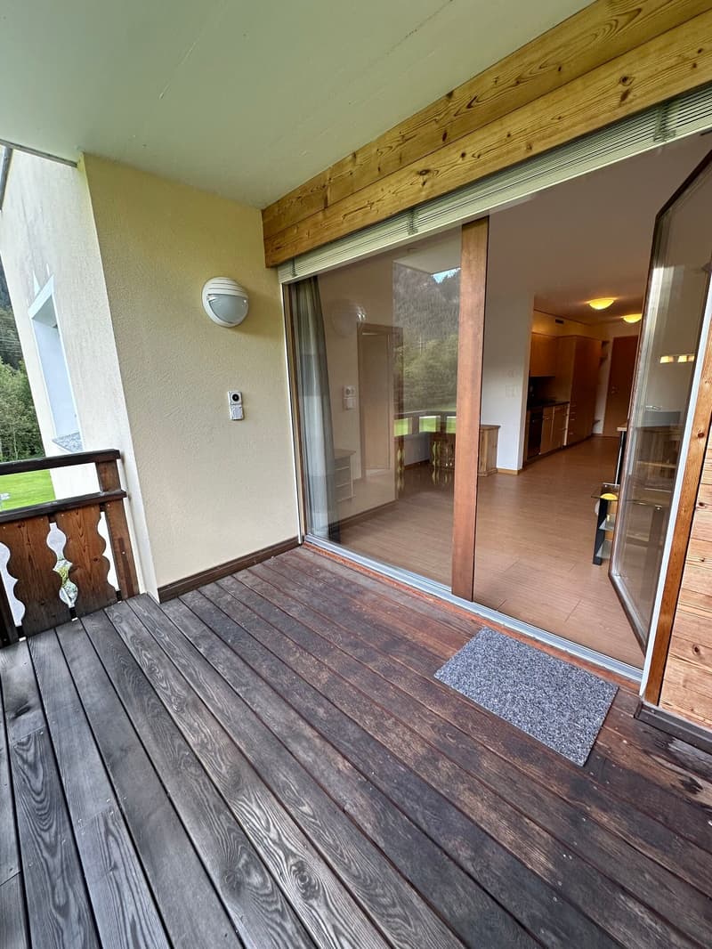 wooden railings, wooden floor, open sliding glass doors, grass field view