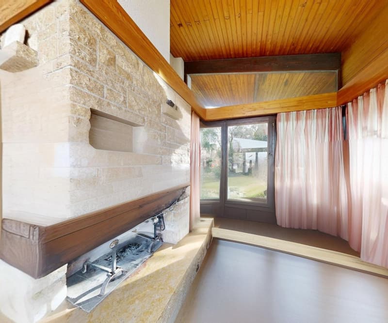 wooden ceiling, stone fireplace, large glass door with view to the garden