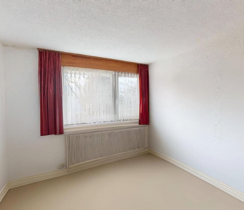 white walls, floor, window with white curtain, red curtain, white radiator