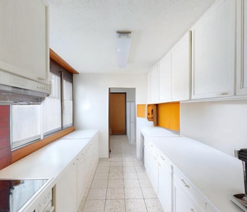 kitchen with white cabinets, white countertops, large window
