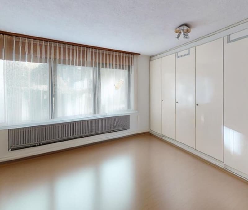 empty room, wooden floor, large window, radiator, white wardrobe