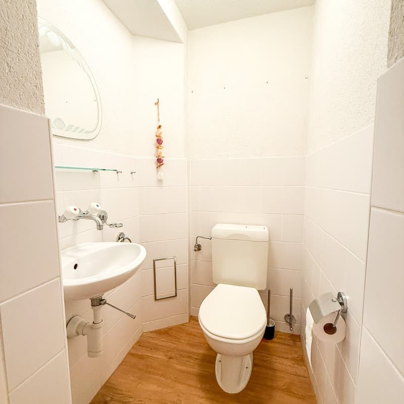 Small bathroom with toilet, sink, and white tiles