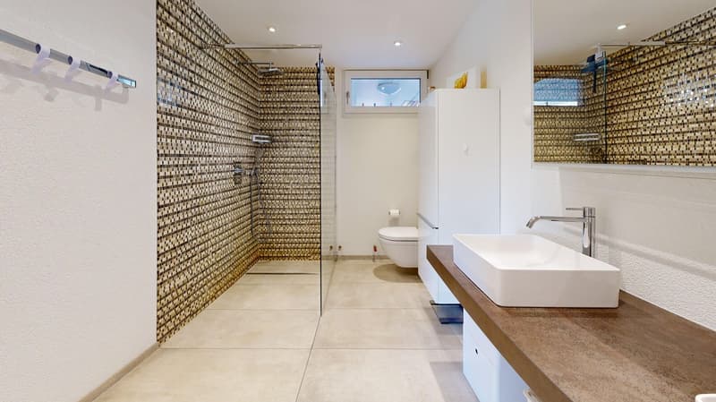modern bathroom with shower, toilet, sink, and tiled walls
