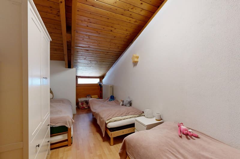 Three beds, wooden floor, white walls, wooden ceiling, white nightstands, white wardrobe