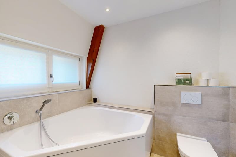 Bathroom with bathtub, toilet, and window