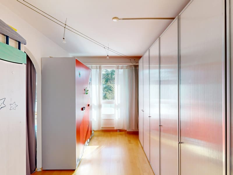 long hallway with white walls, wooden floor, white and red wardrobes, white curtains, white radiator