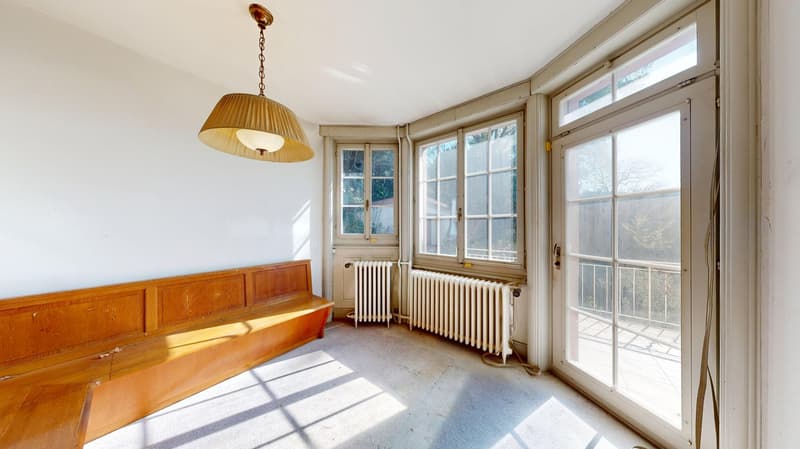 empty room, wooden bench, white walls, white radiators, large windows, balcony, view of trees