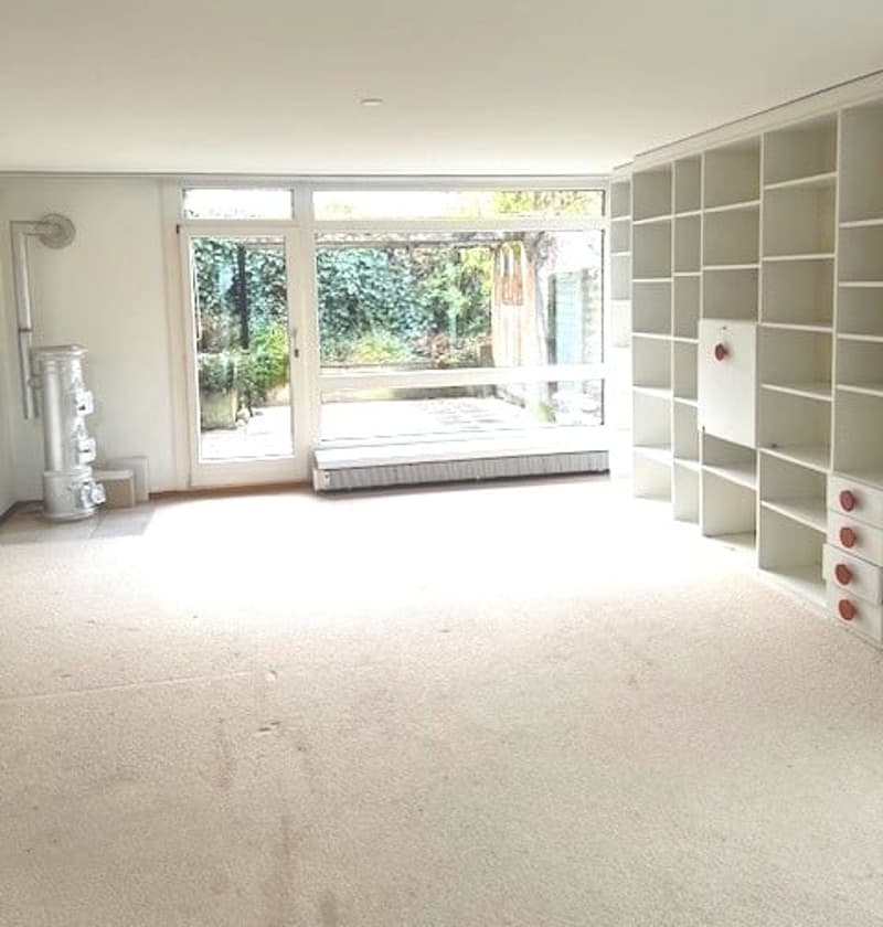 wide, empty room, with a tall bookshelf, balcony, sliding glass door