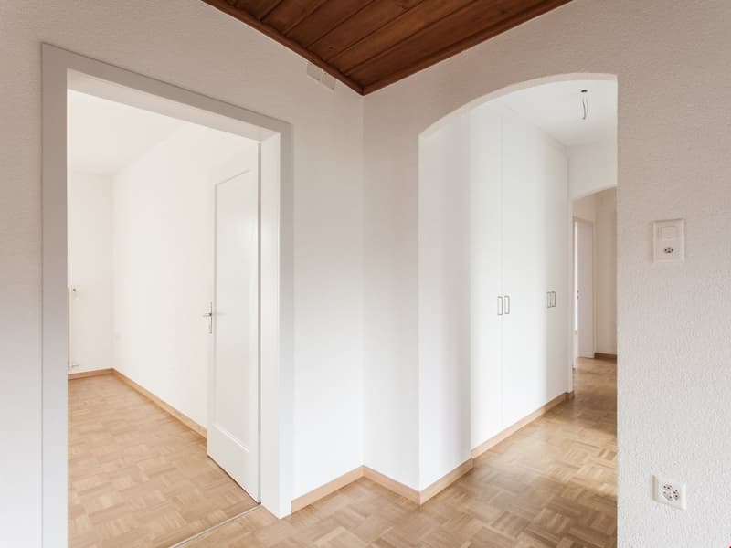 empty room, white walls, wooden floor, archway, door, power outlets