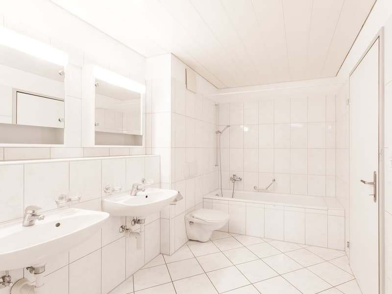 Spacious bathroom, white tiles, double sinks, bathtub, shower, toilet