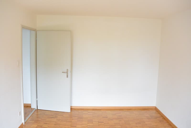 empty room, white walls, wooden floors, closed door