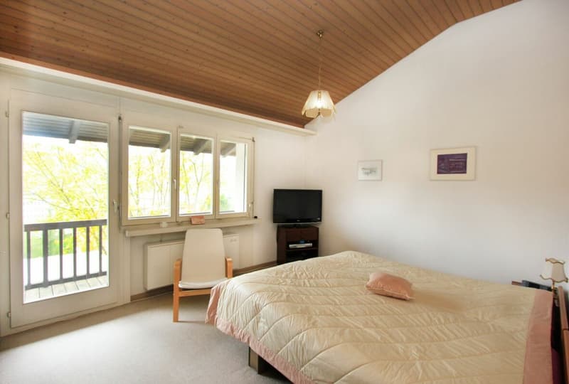 Schlafzimmer im Obergeschoss mit Zugang zum Balkon