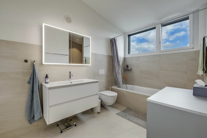 Grosses Badezimmer mit Badewanne, WC, grossem Lavabo, beleuchtetem Spiegel inklusive Unterschrank...