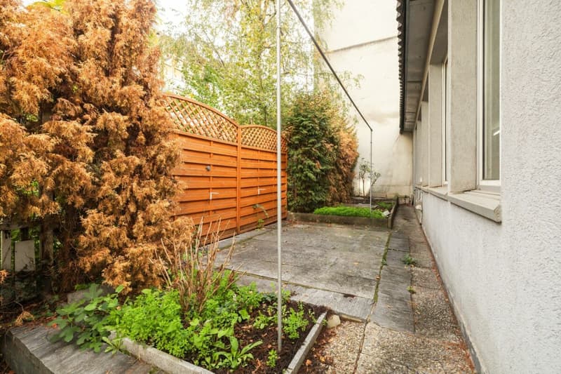 Sitzplatz und kleine Gartenbeete im Hinterhof